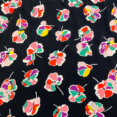 A beautiful floral motif design blocked with colours in light green, orange, pink and yellow incased in a white outline all against a black background. Viscose fabric is a semi-synthetic type of Rayon, made from wood pulp it gives a smooth silk like finish and as a light weight fabric will drape well across the body. It makes it an ideal sewing fabric because of it’s versatility, and perfect for a number of sewing projects, including dresses, skirts, blouses and summer trousers to name a few. 