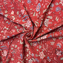 Load image into Gallery viewer, Introducing the Dutch Heritage Surat in red, a wonderful rayon fabric. It has a beautiful floral design with colours such as pastel green, blue and pink with hints of black with vines weaving between the floral motifs against a brick background. It is light weight and has an amazing drape, making it a versatile sewing fabric as it can be used for a number of sewing projects, including dresses, skirts, blouses and trousers to name a few.
