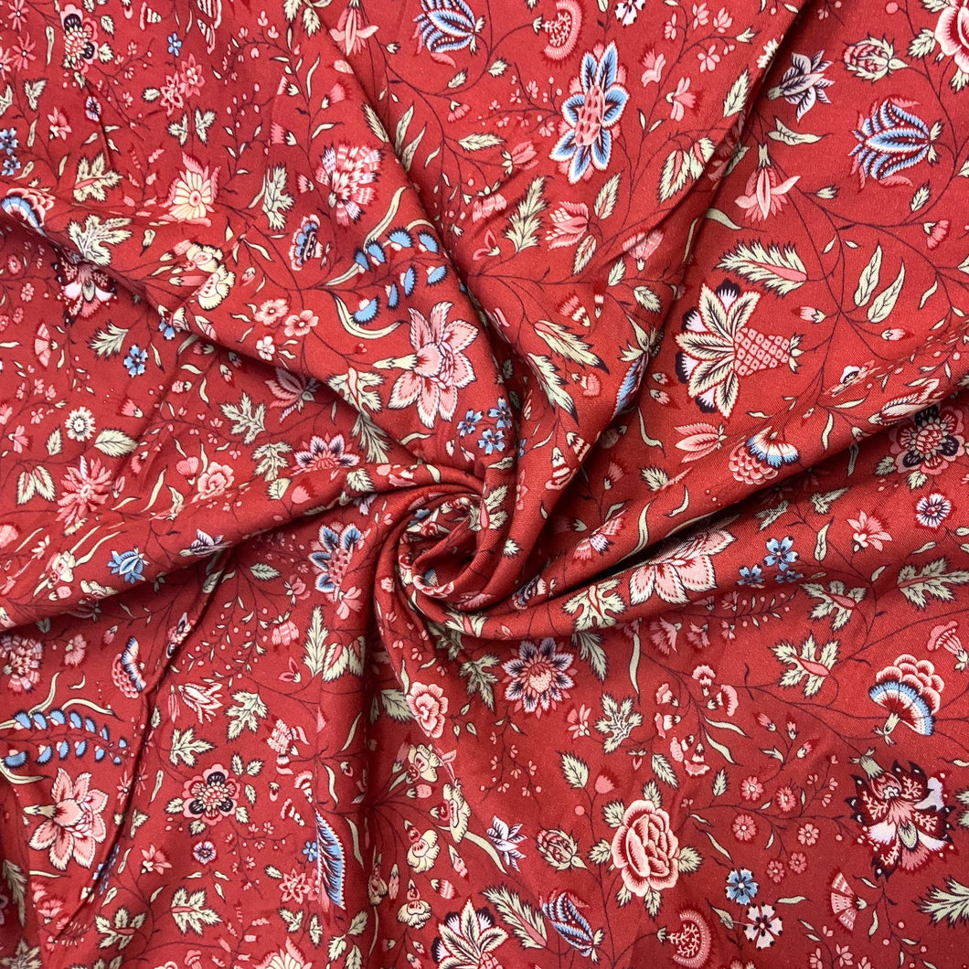 Introducing the Dutch Heritage Surat in red, a wonderful rayon fabric. It has a beautiful floral design with colours such as pastel green, blue and pink with hints of black with vines weaving between the floral motifs against a brick background. It is light weight and has an amazing drape, making it a versatile sewing fabric as it can be used for a number of sewing projects, including dresses, skirts, blouses and trousers to name a few.