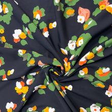 Load image into Gallery viewer, A beautiful floral motif design which includes colours such as yellow, orange and red against a black background. Viscose fabric is a semi-synthetic type of Rayon, made from wood pulp it gives a smooth silk like finish and as a light weight fabric will drape well across the body. It makes it an ideal sewing fabric because of it’s versatility, and perfect for a number of sewing projects, including dresses, skirts, blouses and light trousers to name a few. 
