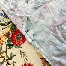 Load image into Gallery viewer, Introducing this amazing Italian deadstock sewing fabric. A lovely quality fabric in a linen and viscose mix with a vintage inspired floral design. The print has an array of bold flowers in red, blue, yellow and lilac against a light peach background. Linen is a great fabric to use because it feels light and is breathable, combined with viscose which has a great drape. It is an ideal dressmaking material for clothing such as dresses, skirts, trousers but also great for light furnishings.
