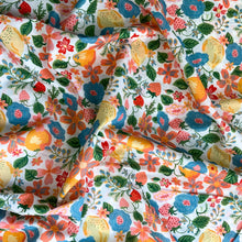 Load image into Gallery viewer, A wonderful cotton lawn fabric from Monaluna. The fabric is called Orchard and it is a lovely design, a high quality cotton lawn that features wonderful fruits such as lemons, oranges and strawberries along with various flowers in rich colours including peach, red, orange yellow and blue, just to name a few against a white background. Pima Cotton Lawn is a plain weave textile, with a crisp finish, it also has an added bonus of being extremely light weight, with a smooth silk like touch.
