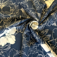 Load image into Gallery viewer, A cotton poplin fabric with a design inspired by the Mallow flower in a white stencilled style along with the flower in contrasting white, against a navy background. The cotton poplin has a smooth handle and a slight drape, it would be a perfect sewing fabric for dressmaking projects or craft.
