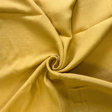 Load image into Gallery viewer, A lovely Tencel Linen blend fabric. It has a soft and lovely drape and a matte texture in a wonderful Amber colour. It would make a number of garments including Dresses, Blouses, Jumpsuits and skirts.  TENCEL™ is made from renewable raw materials and manufactured using environmentally responsible production process. These are certified biobased fibres, and they are certified because they can be compostable and biodegradable, so better and safer for the environment.  
