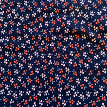 Load image into Gallery viewer, Introducing this wonderful jersey fabric by Poppy Designed for you Europe. This floral and organic jersey has various little daisy like flowers in peach and blush pink on a deep navy background. It is a medium weight cotton jersey and has a good stretch, and can be used for numerous garments, including t-shirts, sweatshirts, dresses, and leggings.
