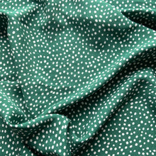 Load image into Gallery viewer, We have this light weight viscose fabric with white circles against a vivid forest green background. An amazing fabric that crosses all seasons.
