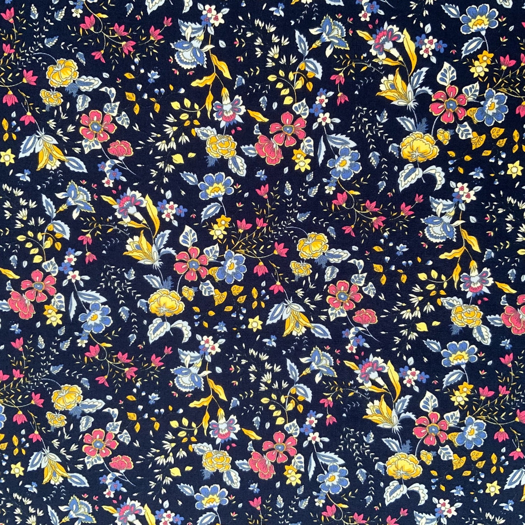 A cotton poplin fabric with a navy themed floral print. The design features vine like flowers with colours in yellow, pink and light blue against a navy background. With a crisp, smooth handle and a slight drape, it would be a perfect sewing fabric for dressmaking projects or craft.
