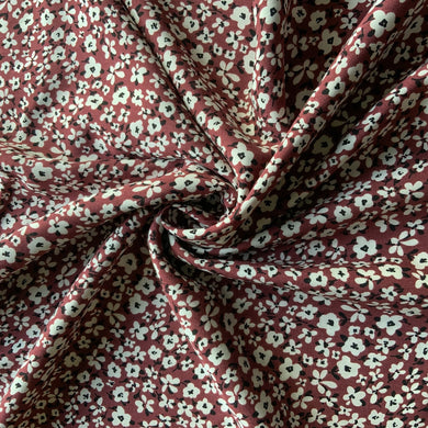 A beautiful light weight viscose fabric great for dressmaking. It has small white flowers, with delicate black centres and leaves against a berry background, a great sewing fabric that works for all seasons. Viscose fabric is a semi-synthetic type of Rayon, made from wood pulp it gives a smooth silk like finish and as a light weight fabric will drape well across the body. It makes it a versatile dressmaking fabric.